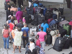 Asylum seekers line up to enter Olympic Stadium near Montreal in this Aug. 4, 2017, file photo. THE CANADIAN PRESS/Paul Chiasson