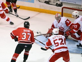 Jack Kopacka ties up the stick of Attack winger Nick Suzuki as he hunts for a loose puck in front of the net in the first period of Game 6 between the Owen Sound Attack and Sault Ste. Marie Greyhounds at the Harry Lumley Bayshore Community Centre on Sunday. Greg Cowan/The Sun Times