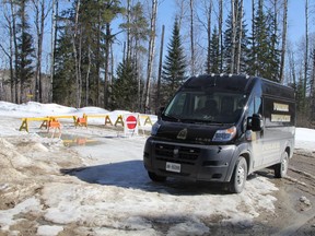 A Timmins Police Service forensic identification van is seen parked on Dalton Road, in front of the barricades where Price Road was closed on Saturday. Six kilometres beyond this barierr, police say a charred 2004 Chrysler Intrepid was discovered with the human remains of four individuals.   Saturday April 21, 2018. Ron Grech/Postmedia Network