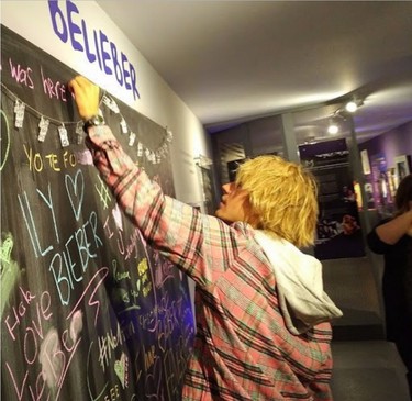 Justin Bieber signs a message board at an exhibit about the pop superstar at the Stratford Perth Museum on Friday during an unexpected visit with his grandparents to his hometown. Bieber spent about 45 minutes in the exhibit. The Steps to Stardom collection profiles his rise to fame.