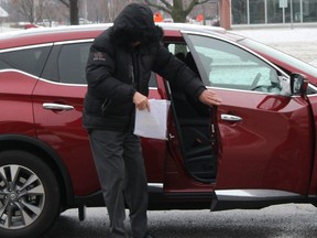 Claude Eric Trachy continued to keep his face hidden from view when arriving at the Chatham Court House in Chatham, Ont. on Friday April 6, 2018. (Ellwood Shreve/Postmedia Network)