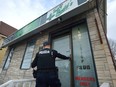 A London police officer enters the Tasty Budd's compassion club on Wharncliffe Road during a raid on marijuana dispensaries in London on February 21, 2017. (MORRIS LAMONT/THE LONDON FREE PRESS)