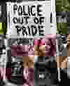 A marcher carries a sign questioning whether police should be marching in the annual Gay Pride Parade on Queens Avenue in London in 2017. (File photo)