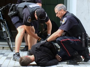 Police arrest a man near Dundas and Richmond streets in this file photo. (DALE CARRUTHERS, The London Free Press)