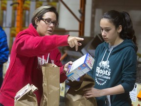 Joana Buzali and her daughter Selmika, 14 Buzali sort groceries at the London Food Bank. Joana said they were volunteering for the first time at the Food Bank just, "for the sake of helping, it's great to help out," and her daughter Selmika can use the hours for her community service hours for confirmation. (MIKE HENSEN, The London Free Press)