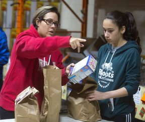 Joana Buzali and her daughter Selmika, 14 Buzali sort groceries at the London Food Bank. Joana said they were volunteering for the first time at the Food Bank just, "for the sake of helping, it's great to help out," and her daughter Selmika can use the hours for her community service hours for confirmation. (MIKE HENSEN, The London Free Press)