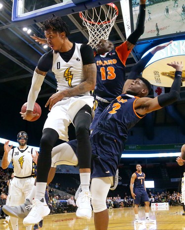 Mo Bolden of the London Lightning, cramped by Island Storm defenders Du'Vaughan Maxwell and Meshack Lufile,  makes a nifty backhanded pass to teammate Royce White who makes an an easy dunk.
Mike Hensen/The London Free Press