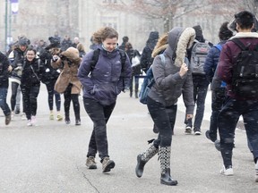 Students struggle against strong winds while traveling between classes at Western University. (DEREK RUTTAN, The London Free Press)