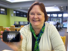 Arlene Thompson, the manager of customer services for the London Public Library, shows the little wifi device they will loan out to allow people to access the internet while away from the library. (MIKE HENSEN, The London Free Press)