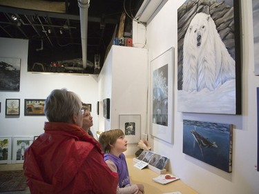 Eight-year-old Ivy Karis is captivated by Kirra Konstantinovna’s painting of a polar bear. She was there with her aunt Heather Belicka.  (DEREK RUTTAN, The London Free Press)