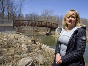 Renee Agathos, pictured in front of one the bridges already installed north of Fanshawe Road, says that a paved pathway will help improve accessibility as well as keep people from wandering off path into environmentally sensitive areas. (MIKE HENSEN, The London Free Press)