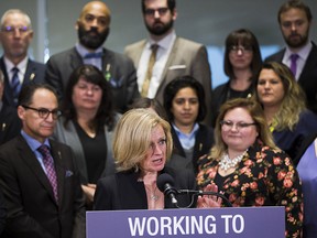 Flanked by her caucus, Alberta Premier Rachel Notley talks about new legislation giving Alberta the power to restrict the flow of oil, gasoline and natural gas leaving the province.