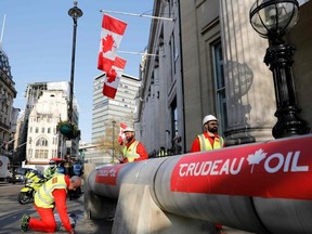 Demonstrators use a mock oil pipeline to block the entrance to the Canadian Embassy in London on Wednesday, April 18, 2018, as they protest against the Trans Mountain oil pipeline from Alberta's oil sands to the Pacific Ocean. (Tolga Akmen/AFP/Getty Images)