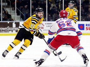 Sarnia Sting's Mitch Eliot, left, tries to carry the puck past Kitchener Rangers' Austin McEneny at Progressive Auto Sales Arena in Sarnia, Ont., on Wednesday, March 14, 2018. (MARK MALONE/Postmedia Network)
