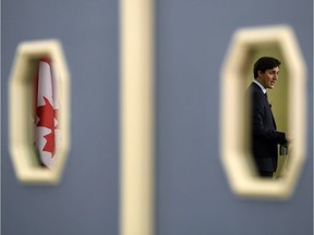 CORRECTS SPELLING OF BYLINE TO TANG Prime Minister Justin Trudeau is seen in a mirrored door window as he speaks at the Skandinaviska Enskilda Banken (SEB) Annual Corporate Client Conference in Ottawa on Monday, March 19, 2018.