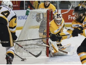 Kingston Frontenacs goaltender Jeremy Helvig keeps a close eye on Hamilton Bulldogs forward MacKenzie Entwistle as Fronts forward Ryan Cranford reaches to block the puck during the first period of Ontario Hockey League Eastern Conference final action at the Rogers K-Rock Centre in Kingston, Ont. on Sunday, April 22, 2018. JULIA MCKAY/Postmedia Network