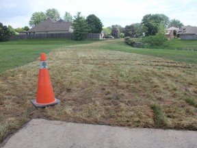 A new pathway in Southwest Optimist Park was created to link residential streets on the east and west sides of the park. But almost immediately after it was built, the path had to be ripped up and replaced with sod, because it was laid down too close to a baseball diamond. (MEGAN STACEY/The London Free Press)