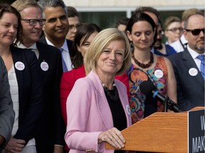 Surrounded by members of her NDP caucus, Alberta Premier Rachel Notley announces that the Government of Canada, with support from the Government of Alberta, has purchased the Trans Mountain Pipeline and associated assets, during a press conference outside the Alberta Legislature in Edmonton Tuesday May 29, 2018.