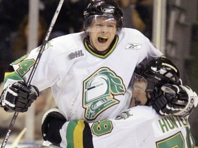 Knights Corey Perry leaps in the air and team mate Dylan Hunter's arms after breaking the all-time Knight's team scoring record, March 15, 2005. (File photo)