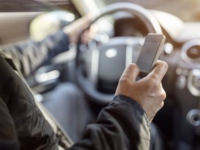 A school has asked parents waiting in a line of vehicles to pick up their kids not to use cellphones. Getty Images/iStockphoto