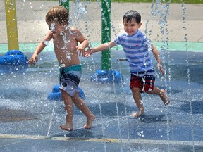Two boys cool off at the splash pad in Gibbons Park. (MORRIS LAMONT, The London Free Press)