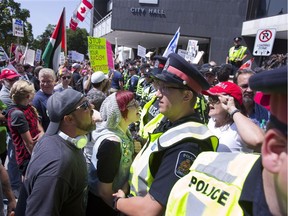 Police formed a line to separate Pegida prostesters (right) and counter-protesters outside of city hall in London, Ont. on Saturday, August 26, 2017.  (DEREK RUTTAN, The London Free Press)