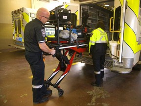 Middlesex-London EMS paramedics Don Black and Samantha Quinlan pull a stretcher from an ambulance.  (Mike Hensen/The London Free Press)