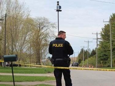 OA member of the OPP  traffic unit uses and instrument that measures distances and angles at the scene of a suspicious death investigation on Front Road north of Vanstra, Ont. on Friday. DALE CARRUTHERS / THE LONDON FREE PRESS