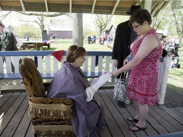 Emily Wing of St. Thomas presents Queen Victoria (played by London-Fanshawe M.P. Irene Mathyssen) with a birthday present of a hand-knitted bracelet at Fanshawe Pioneer Village on Victoria Day. Wing gifted her a hand-knitted scarf two birthdays ago. Derek Ruttan/The London Free Press/Postmedia Network