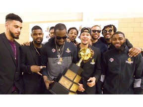Kirk Williams Jr. of the Lightning holds the league championship trophy surrounded by teammates Julian Boyd, left, Kyle Johnson, Yohanny Dalembert, Marcus Capers, Joel Friesen-Latty, Garrett Williamson, Mo Bolden and Ashton Smith during a meet and greet with their fans at their Blackfriars Road gym. The Lightning came back from a 2-0 deficit to win 4-3 over the Halifax Hurricanes for their fourth league championship, and on Tuesday they celebrated with an open house for their fans. 
Mike Hensen/The London Free Press