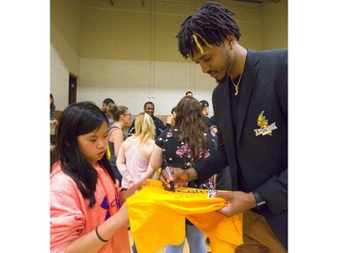 Six-foot-10 Lightning forward Mo Bolden signs a t-shirt for Lily Wright, 12, during a meet and greet with fans at the Lightnings' Blackfriars Road gym. The Lightning came back from a 2-0 deficit to win 4-3 over the Halifax Hurricanes for their fourth league championship, and on Tuesday they celebrated with an open house for their fans. 
Mike Hensen/The London Free Press