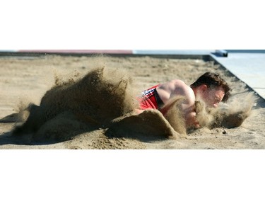 Magnus Thompson of St. Mary's DCVI eats a bit of sand as he lands a jump in the junior boys long jump on Day 2 of WOSSAA at TD stadium on Friday May 25.  Mike Hensen/The London Free Press/Postmedia Network