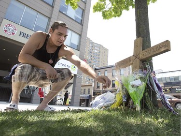 Brodie Elliott sprinkles indian tobacco at memorial for homicide victim Dereck Szaflarski at the corner of Piccadilly Street and Richmond Street in London, Ont. on Monday May 28, 2018. Elliott did not know Szaflarski but lives in the neighbourhood and was compelled to visit the memorial and offer a prayer. "I came to pay respect and honour the spirit he had," he said. "I pray for him and his family." The tobacco is used to help guide the prayer to a higher power. Derek Ruttan/The London Free Press/Postmedia Network