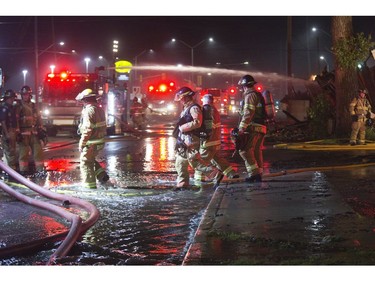 Runoff water flows like a river down the Southdale Road as firefighters work on the fire that destroyed the former Hooks Restaurant in London, Ont. on Wednesday May 30, 2018. Derek Ruttan/The London Free Press/Postmedia Network