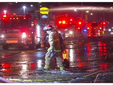 Runoff water flows like a river down the Southdale Road as firefighters work on the fire that destroyed the former Hooks Restaurant in London, Ont. on Wednesday May 30, 2018. Derek Ruttan/The London Free Press/Postmedia Network