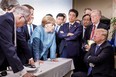 This photo released on Twitter by the German government on Saturday shows U.S, President Donald Trump, right, talking with German Chancellor Angela Merkel, centre, and surrounded by other G7 leaders during a meeting of the G7 summit in La Malbaie, Que,. (AFP Photo/Bundesregierung/Jesco DENZEL)