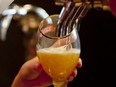 A server pours beer from a tap at a bar in London.  (File photo)