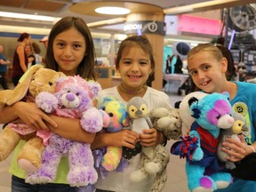 Nine-year-old Alivia, left, seven-year-old Avary and eight-year-old Maddy show off their stuffed animals, including new teddy bears, at Wednesday's 25th annual Teddy Bear Picnic at the Children's Hospital in London for its patients and outpatients. (SHANNON COULTER, The London Free Press)