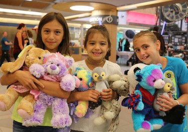 Nine-year-old Alivia (left), seven-year-old Avary and eight-year-old Maddy show off their stuffed animals, including new teddy bears, at the 25th annual Teddy Bear Picnic on Wednesday. It was held at the Children's Hospital in London. (SHANNON COULTER, The London Free Press)