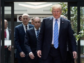 U.S. President Donald Trump, with director of the National Economic Council National Larry Kudlow, centre, and White House chief of staff John Kelly, leaves the G7 summit in La Malbaie, Que., on Saturday. (AFP Photo/Lars Hagberg)