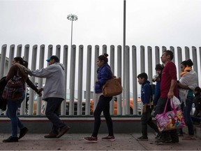 Migrants walk towards El Chaparral port of entry in Tijuana, Mexico, on the border with the United States on June 21, 2018.