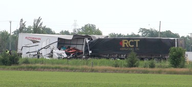 Investigators go over the crash scene involving two tractor trailers that collided head-on after one of the rigs crossed the median on Highway 401, just east of the westbound Tilbury OnRoute service centre near Tilbury, Ont. on Friday June 22, 2018, just before 7 a.m.  (Ellwood Shreve/Postmedia Network)