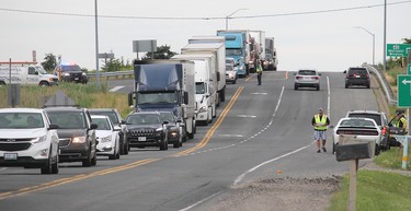 OPP direct traffic that was detoured off the eastbound Highway 401 at the Essex County Road 42 off-ramp just outside of Tilbury, Ont. on Friday June 22, 2018.  (Ellwood Shreve/Postmedia Network)