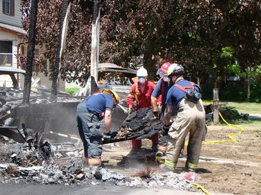 Chesley and Area Fire Department members assist a member of the fire marshal's office with cleanup and sorting through rubble on Tuesday after a house fire claimed three lives in Chesley early Monday morning. After finding the bodies on Monday the focus of the investigation shifted on Tuesday to determining the cause of the fire. (DEREK LESTER, Postmedia Network)