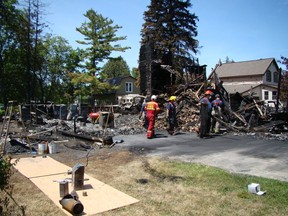 Chesley and Area Fire Department members assist a member of the fire marshal's office with cleanup and sorting through rubble on Tuesday, June 12 after a house fire claimed three lives in Chesley early Monday morning. (DEREK LESTER, Postmedia Network)