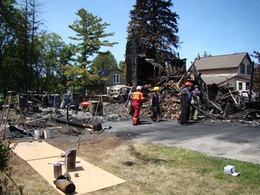 Chesley and Area Fire Department members assist a member of the fire marshal's office with cleanup and sorting through rubble on Tuesday after a house fire claimed three lives in Chesley early Monday morning. After finding the bodies on Monday the focus of the investigation shifted on Tuesday to determining the cause of the fire. (DEREK LESTER, Postmedia Network)