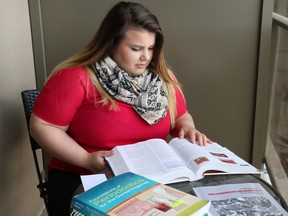 Dental hygiene student Merisa Buragina reviews one of her textbooks on her apartment's balcony. Buragina will graduate from her program on June 7. (SHANNON COULTER, The London Free Press)