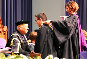 Western University chancellor Jack Cowin, left, speaks with bachelor of medical sciences graduate John Antonio Chmiel while Dr. Sarah McLean places a hood over his shoulders during Western's 311th convocation ceremony on Thursday, June 14, 2018. (DALE CARRUTHERS, The London Free Press)