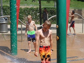 Michael, left, 11, and Will Johnston, 9, cool off in the spray pad at the forks of the Thames River near Ivey Park on Friday. (Shalu Mehta, London Free Press)