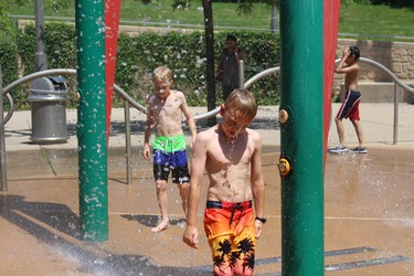 Michael, left, 11, and Will Johnston, 9, cool off in the spray pad at the forks of the Thames River near Ivey Park on Friday. (Shalu Mehta, London Free Press)